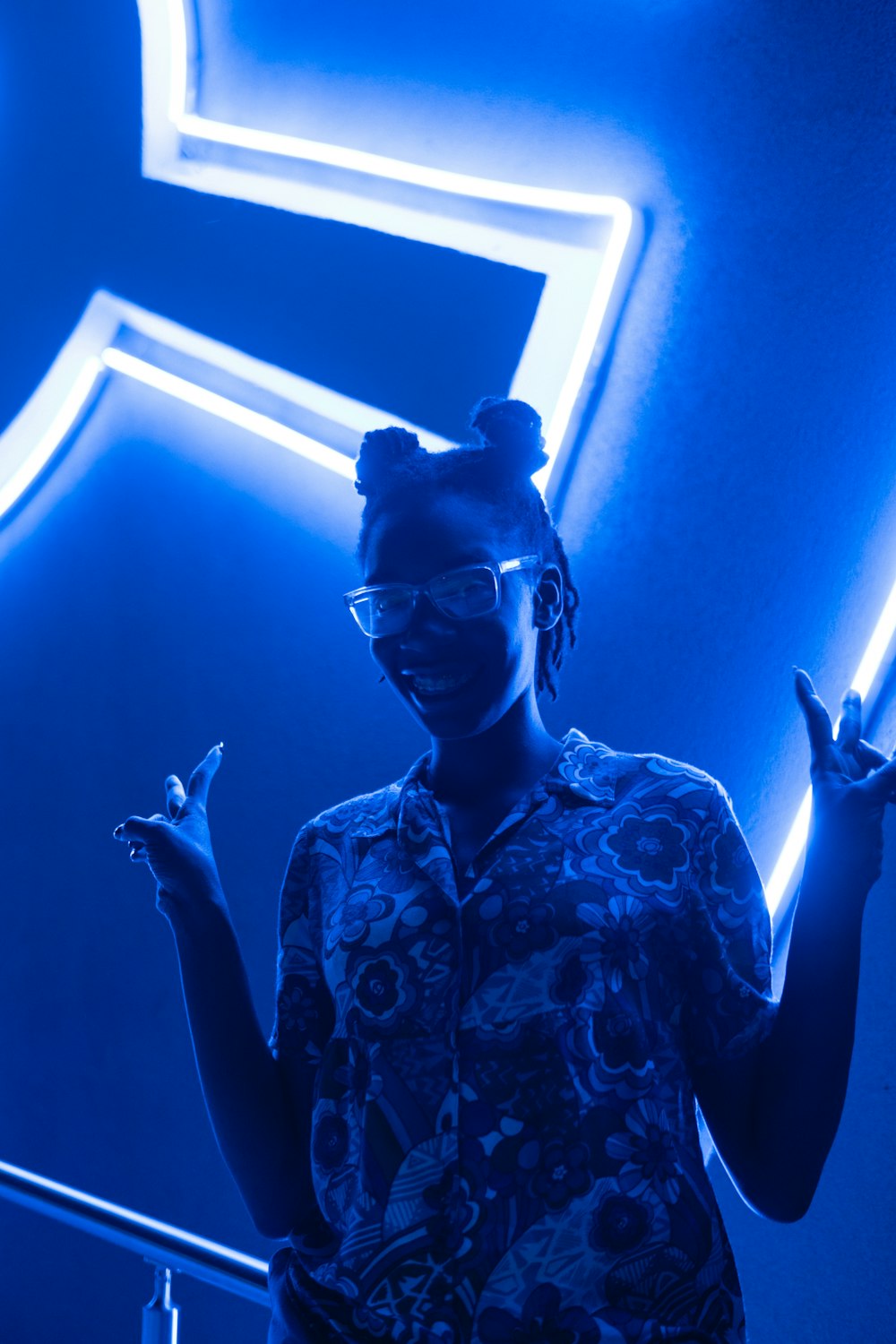 woman standing in front of blue lighted wall