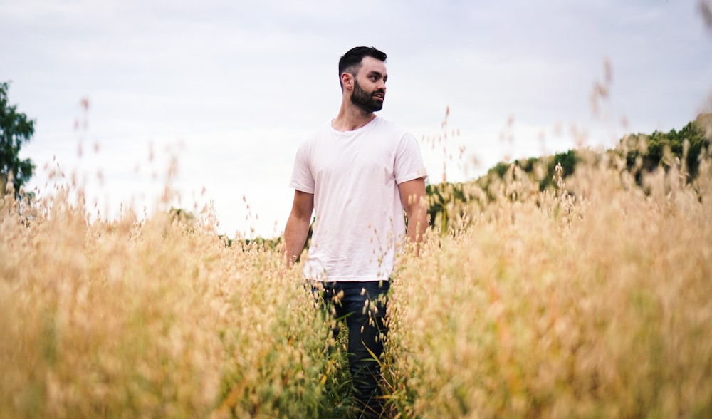 man in white crew-neck t-shirt standing at the fields