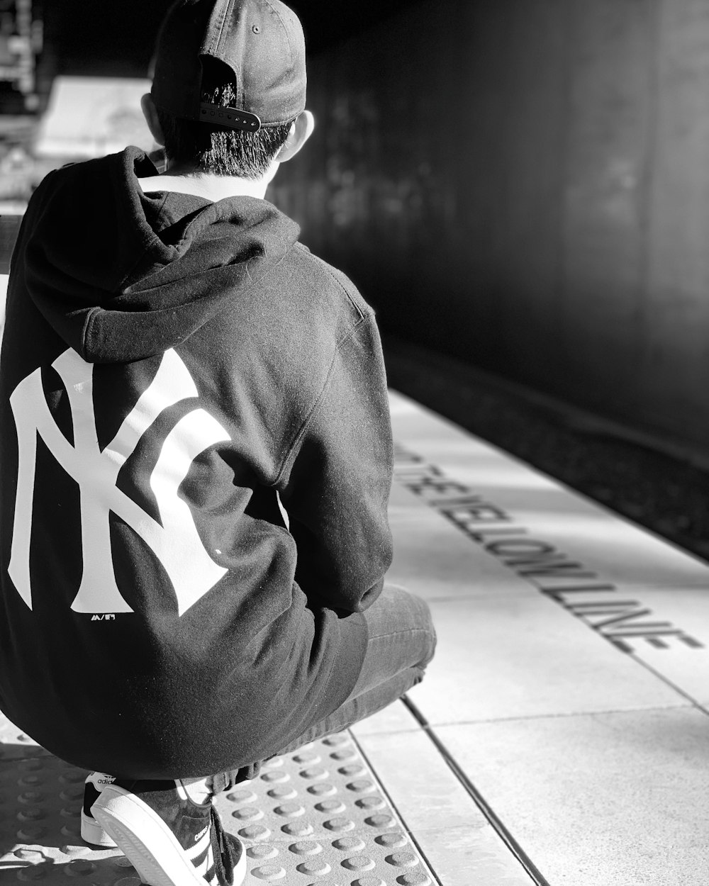 a black and white photo of a man sitting on a bench