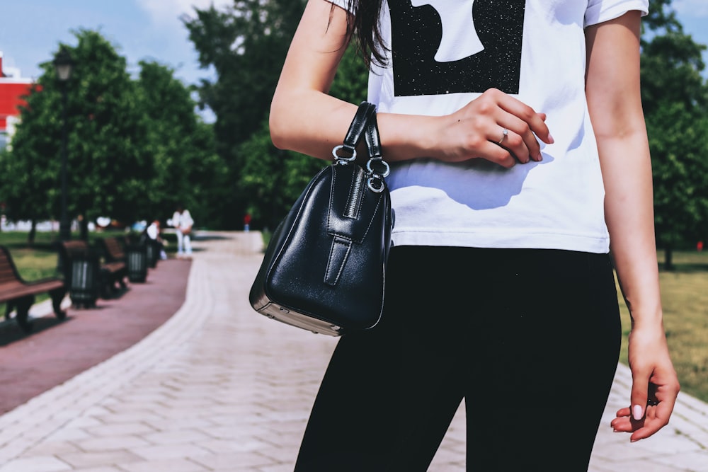 woman wearing white and black t-shirt and black pants