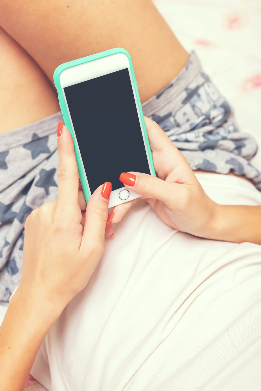 woman holding iPhone with teal case