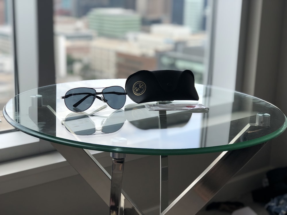 a pair of sunglasses sitting on top of a glass table