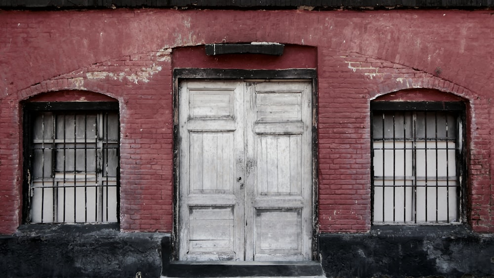 ein rotes Backsteingebäude mit zwei weißen Türen