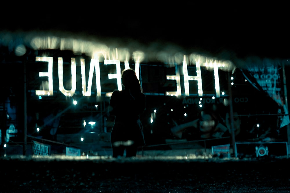 woman looking at lighted neon signage