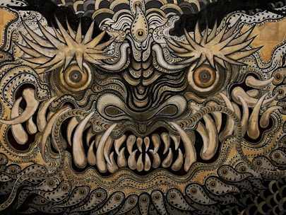 An intricate and detailed abstract depiction featuring swirling patterns and elaborate designs. The image conveys a mythical or fantastical creature with large, expressive eyes and prominent teeth, surrounded by ornate swirls and spiky shapes.