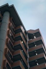 Elegant modern residential building with ocean blue and gold accents under soft natural light.