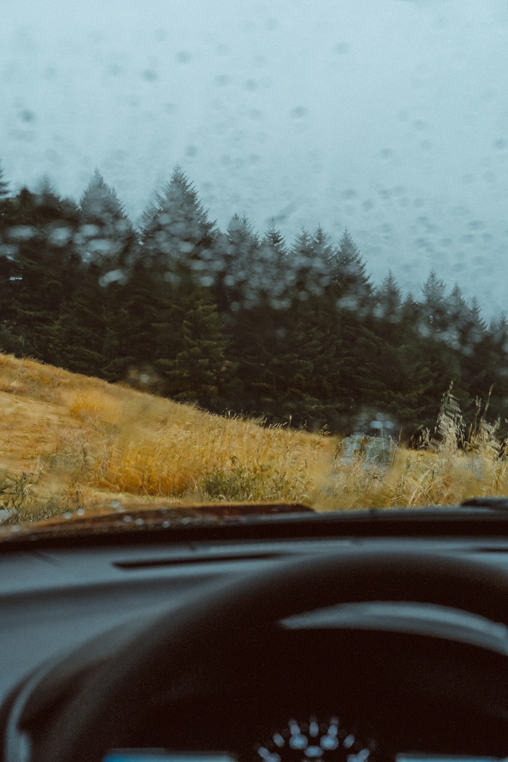 a car driving down a rain soaked road