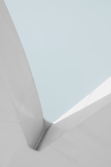 A minimalist architectural structure with clean lines and smooth surfaces. The composition involves a contrast between light grey and soft cyan colors, giving a sense of calm and simplicity.