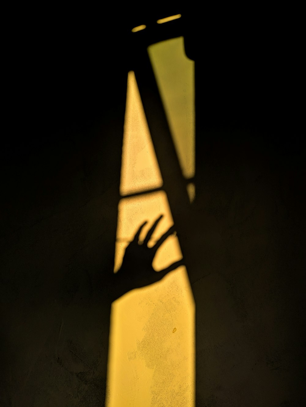 a shadow of a person's hand on a wall