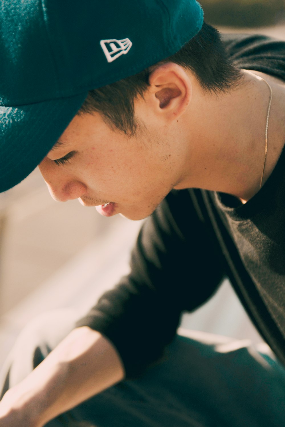 man in black crew-neck long-sleeved shirt with black fitted cap