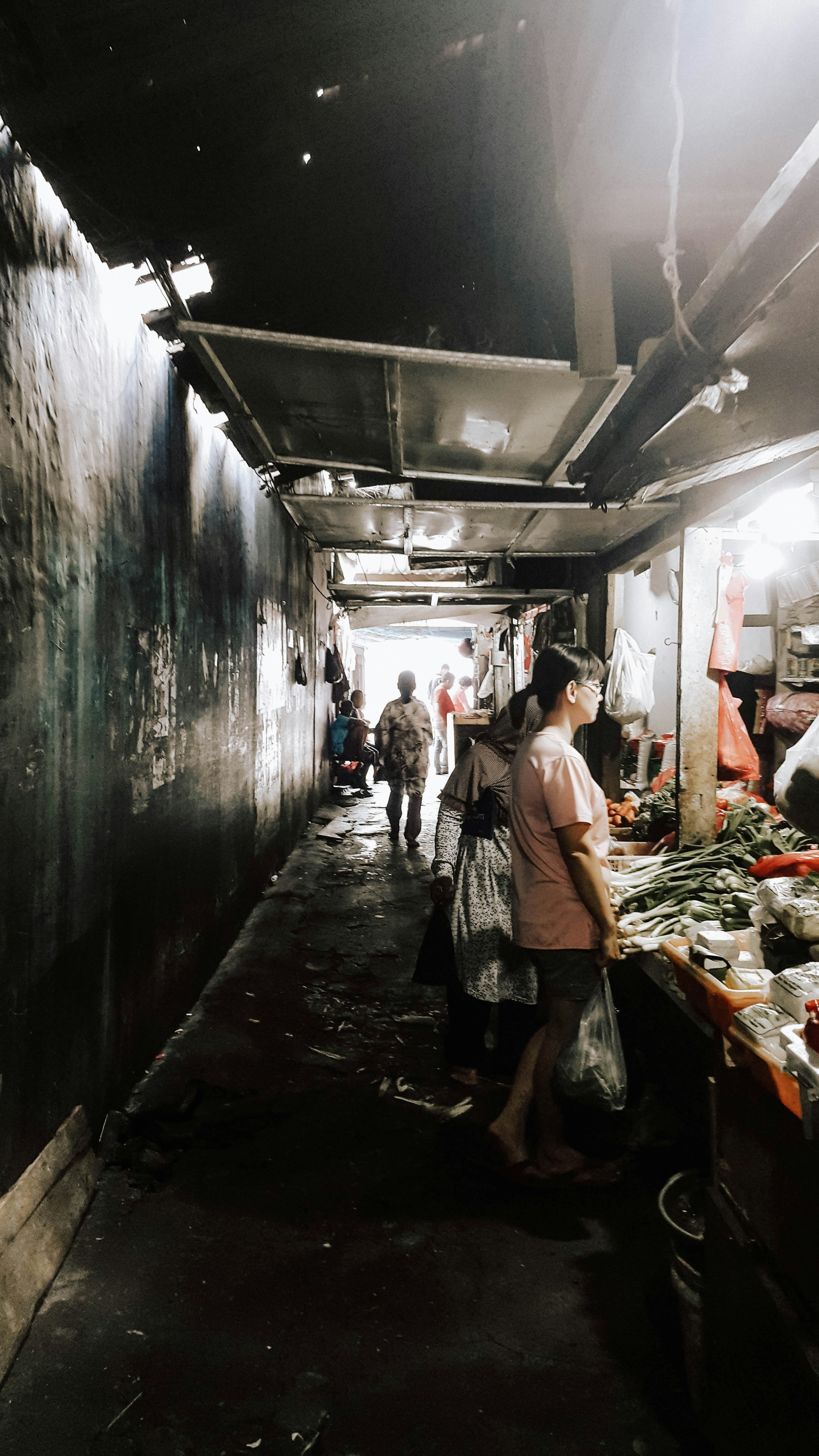 Fresh produce on dark market counter, moody atmospheric lighting, deep shadows