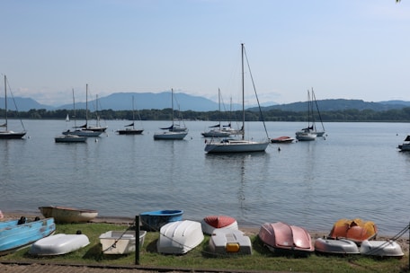 Children enjoying sailing lessons on a calm lake during summer camp.