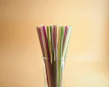 Colorful reusable straws arranged neatly with matching cleaning brushes.