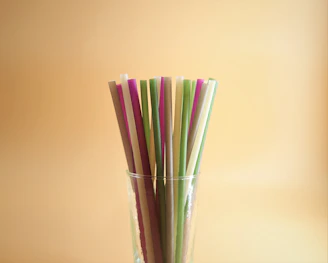 A colorful collection of reusable straws and eco-friendly lunch boxes displayed on a kitchen counter.