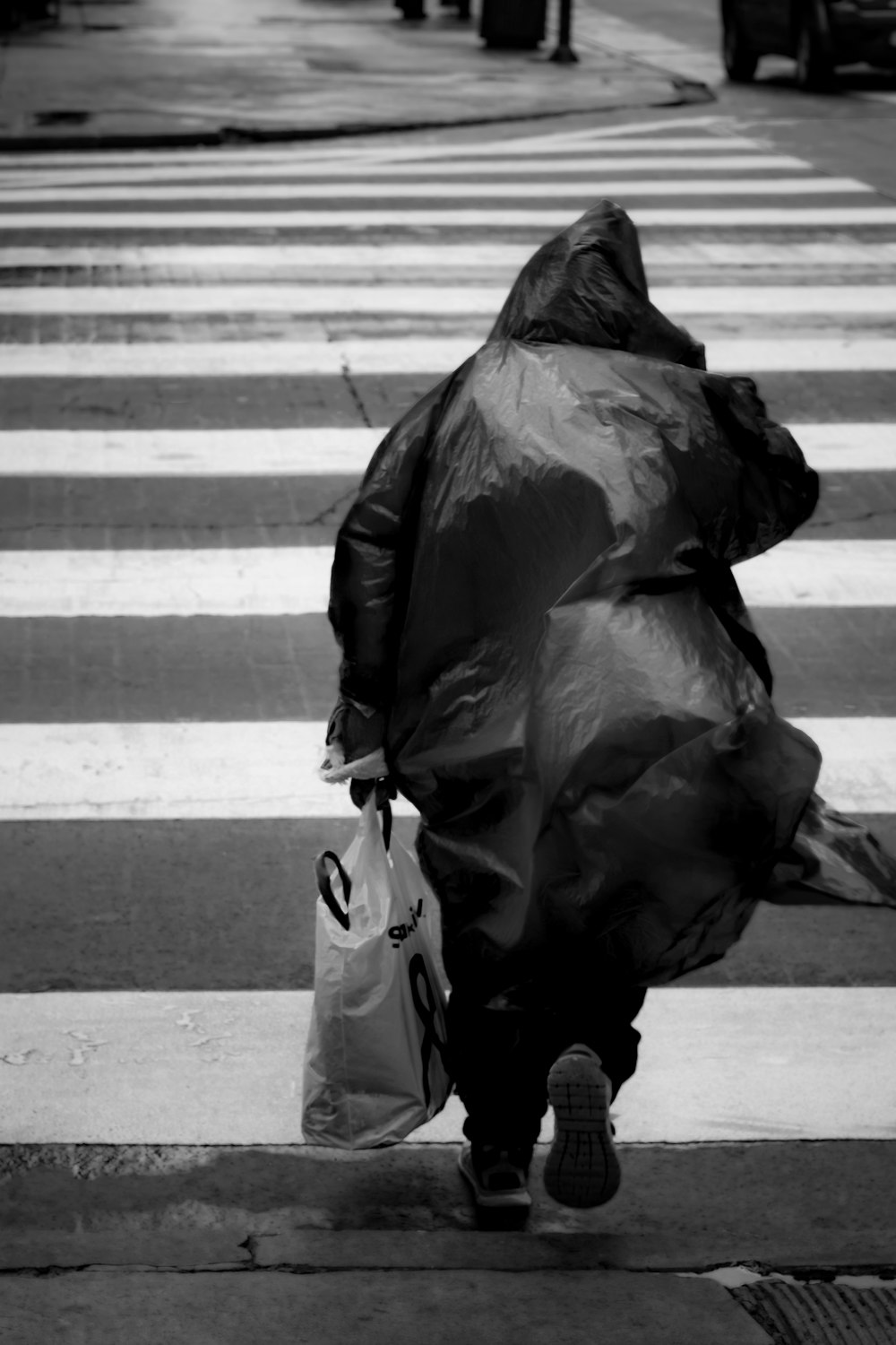 grayscale photo of person crossing the pedestrian lane