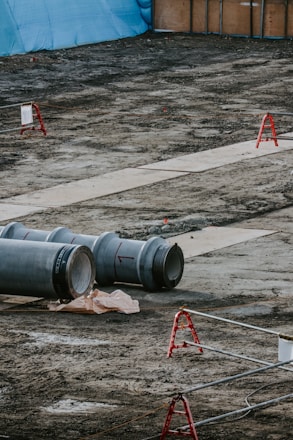 A bustling construction site with pipes and fittings neatly stacked, ready for delivery.