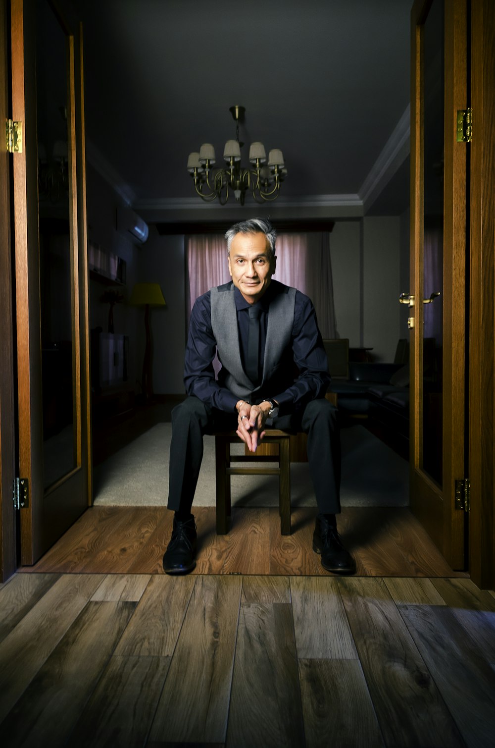 man in vest sitting on chair