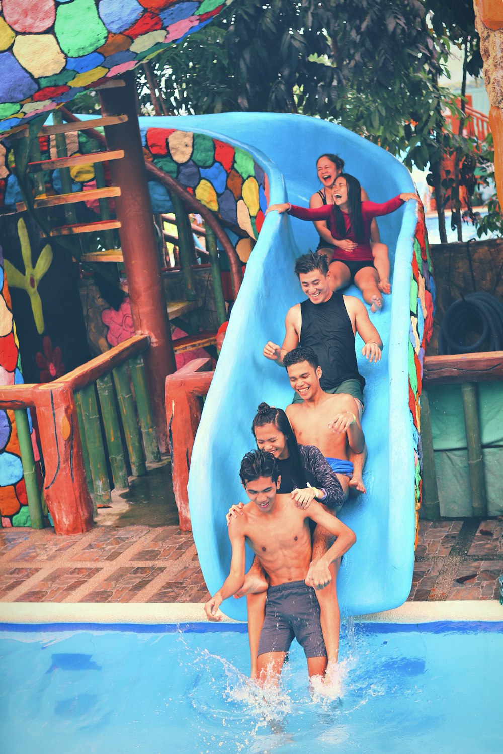 people on blue swimming pool slide