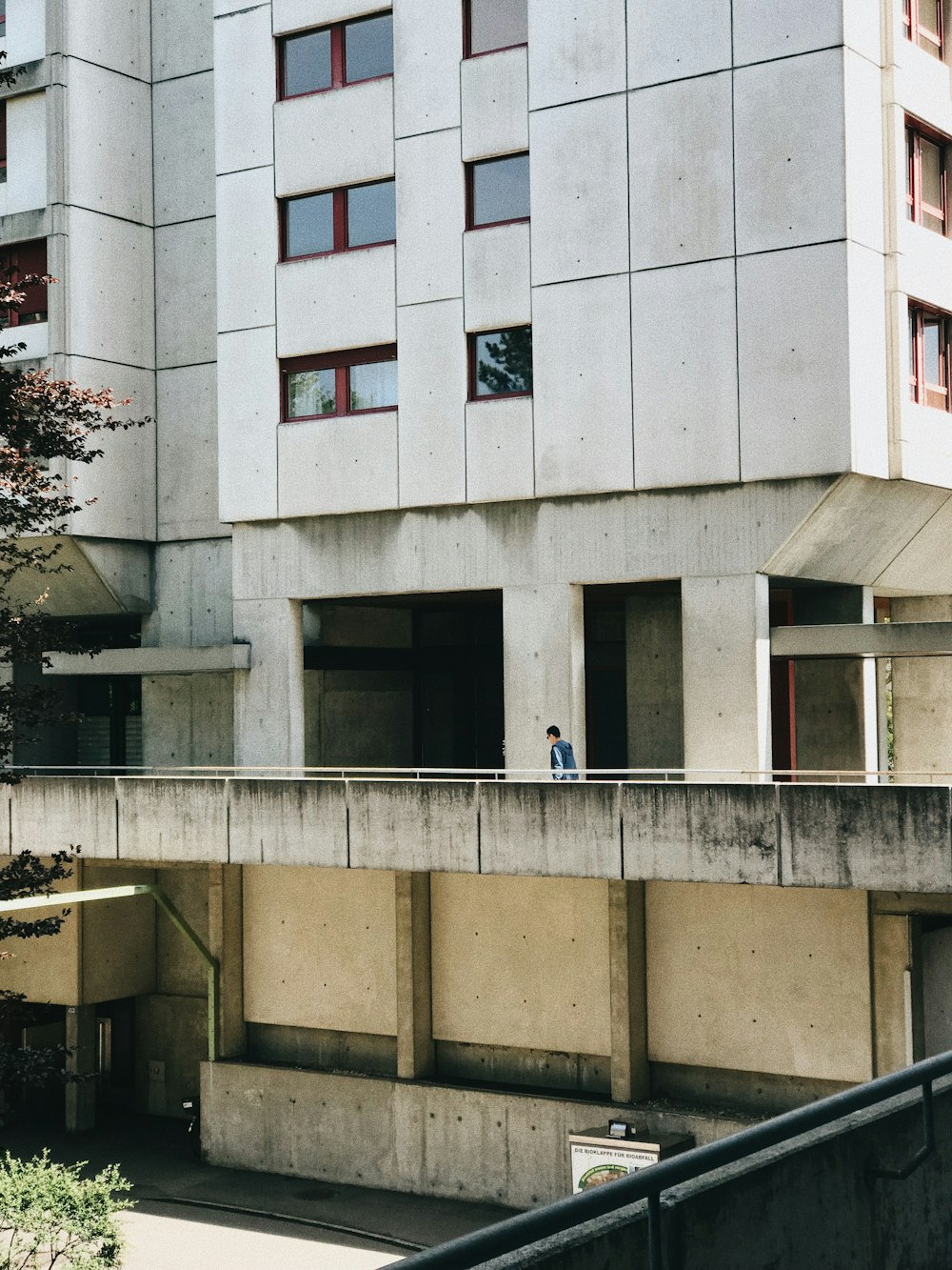 a concrete building with two people standing on the balcony