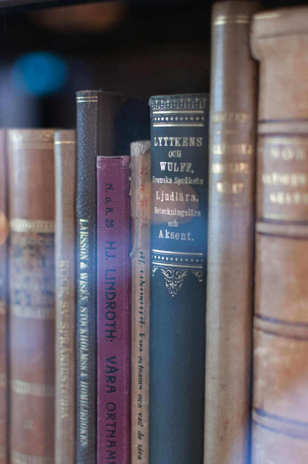 a row of books sitting on top of a book shelf