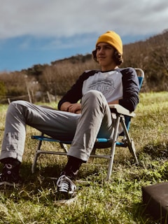 a man sitting in a chair in a field