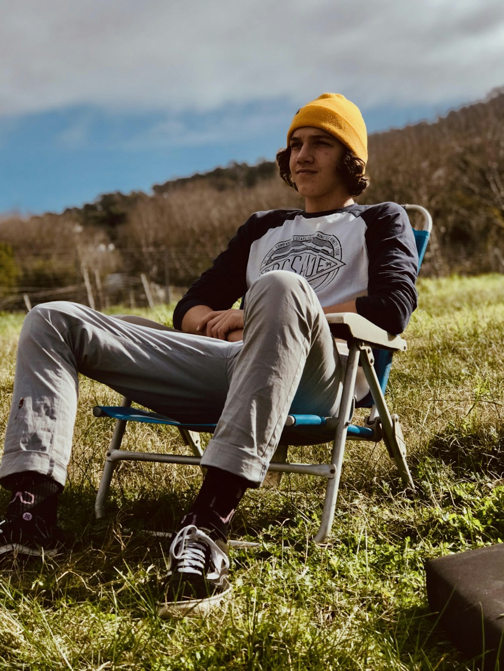 a man sitting in a chair in a field