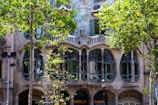 A panoramic shot of a modernist building facade with ornate ironwork and stained glass