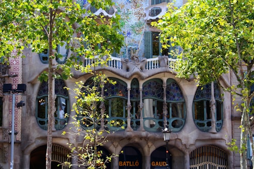 A panoramic shot of a modernist building facade with ornate ironwork and stained glass