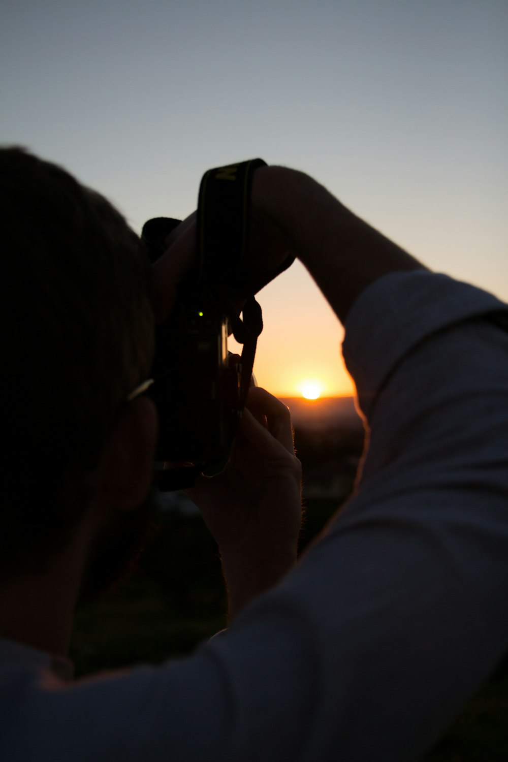 personne utilisant l’appareil photo capturant le coucher du soleil