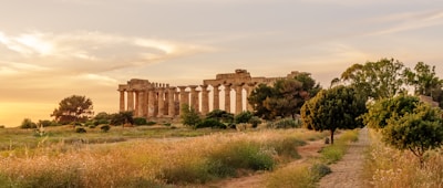 Golden sunlight bathing the Acropolis ruins in Athens at sunset.