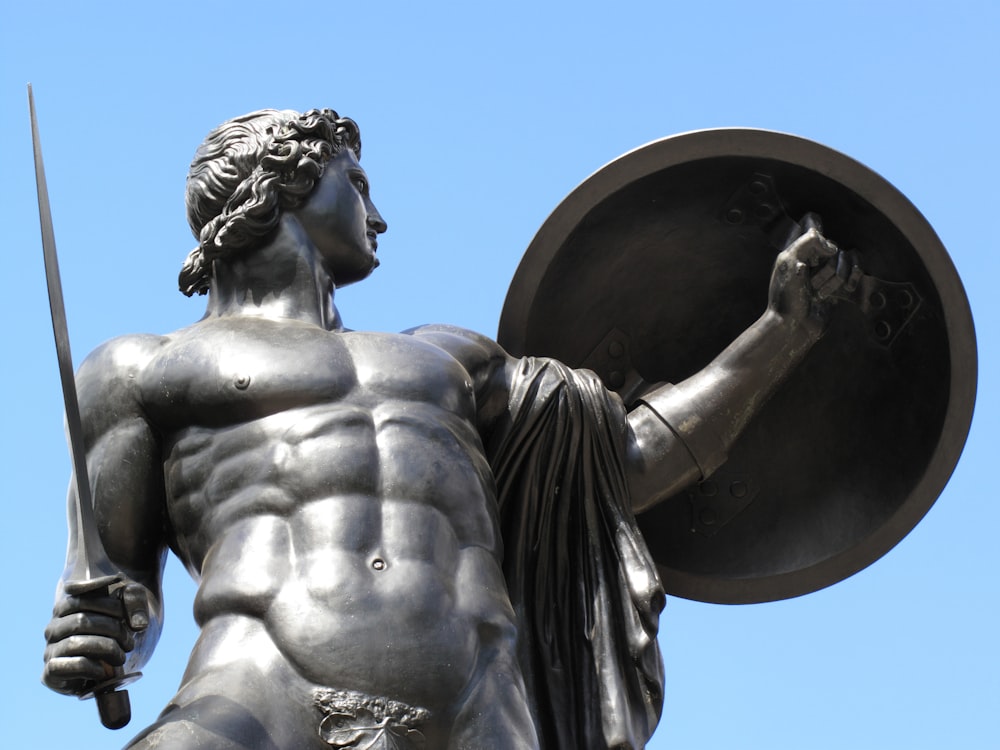 man holding sword and shield statue