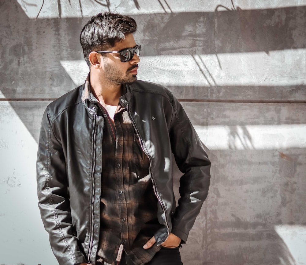 man wearing black leather jacket standing while facing his right side