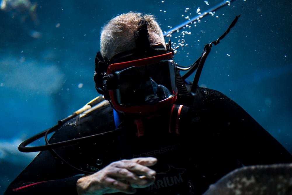 a man in a scuba suit holding onto a rope