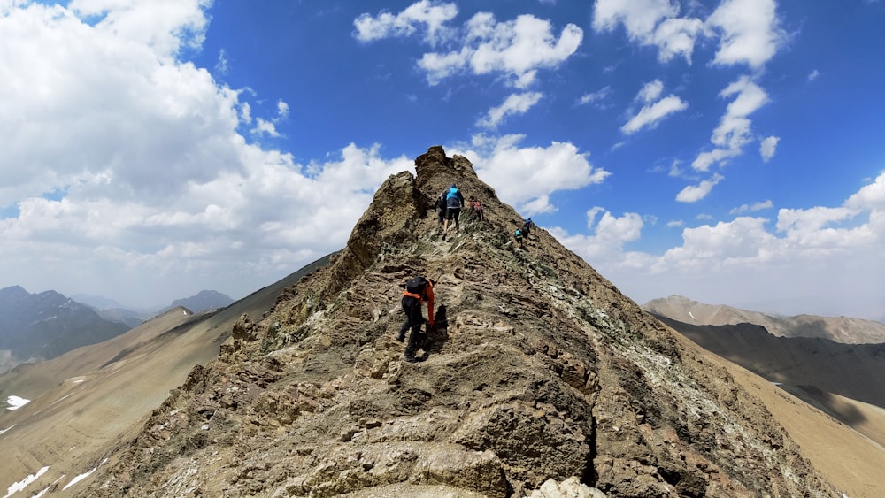 two person climbing on mountain during daytime