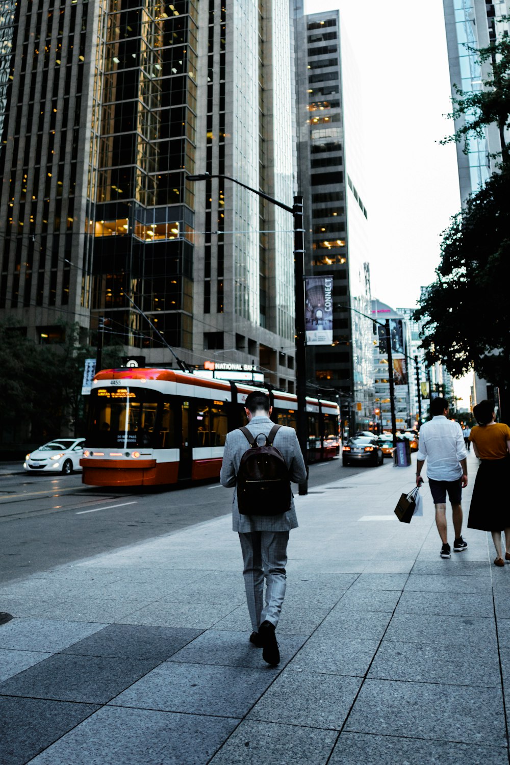 man carrying backpack walking on street