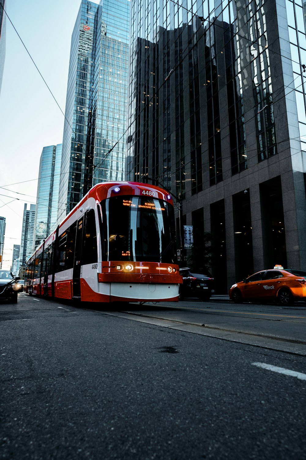 red and white bus parked near grey concrete building