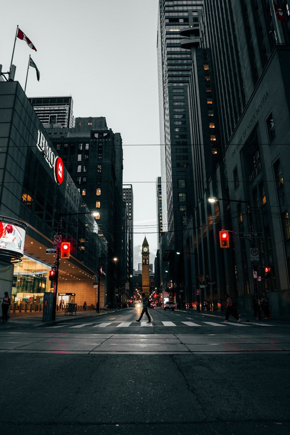 man walking across pedestrian lane between buildings