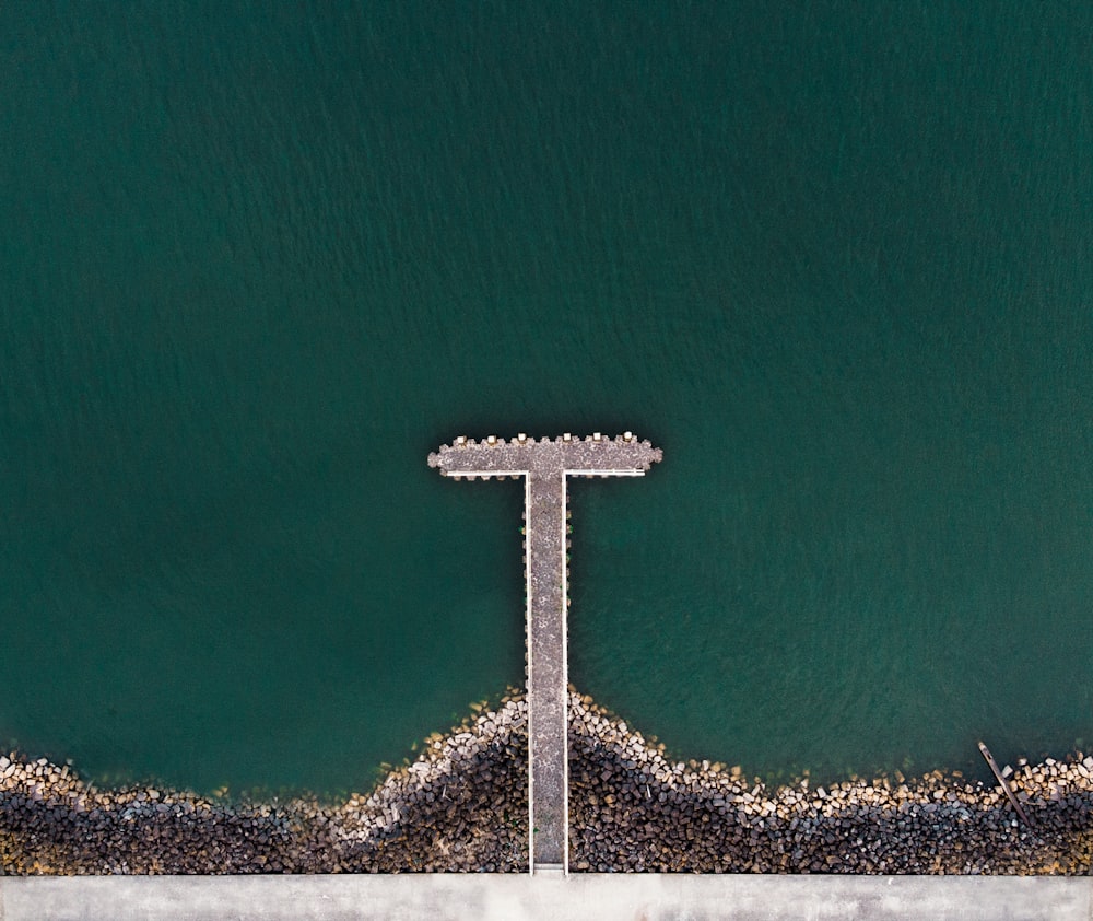 aerial photography of grey dock and green body of water