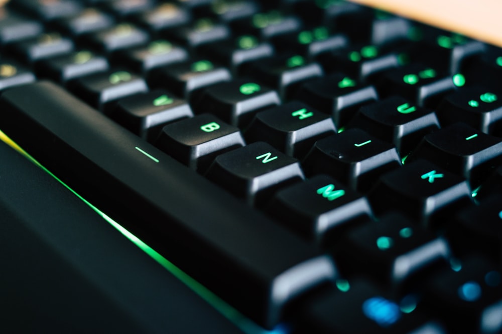 a close up of a black keyboard with green keys