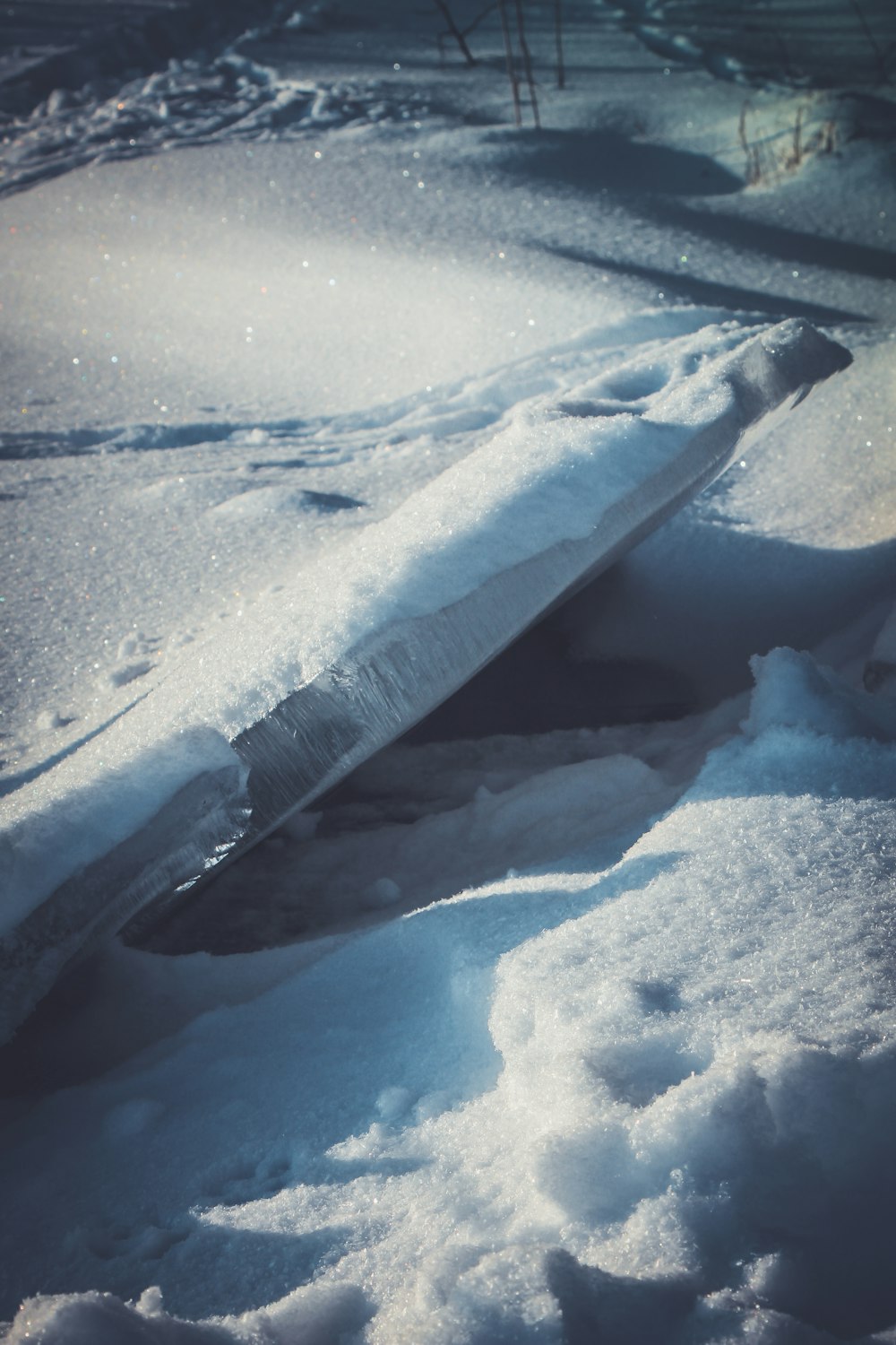 a surfboard laying in the snow on the ground