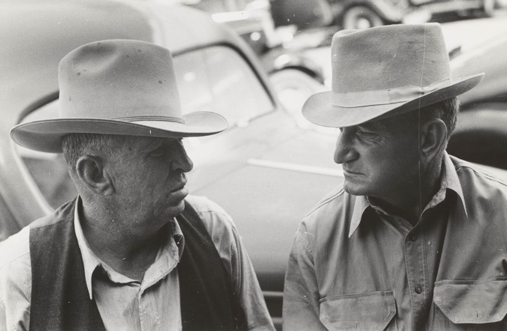grayscale photography of two men wearing cowboy hat
