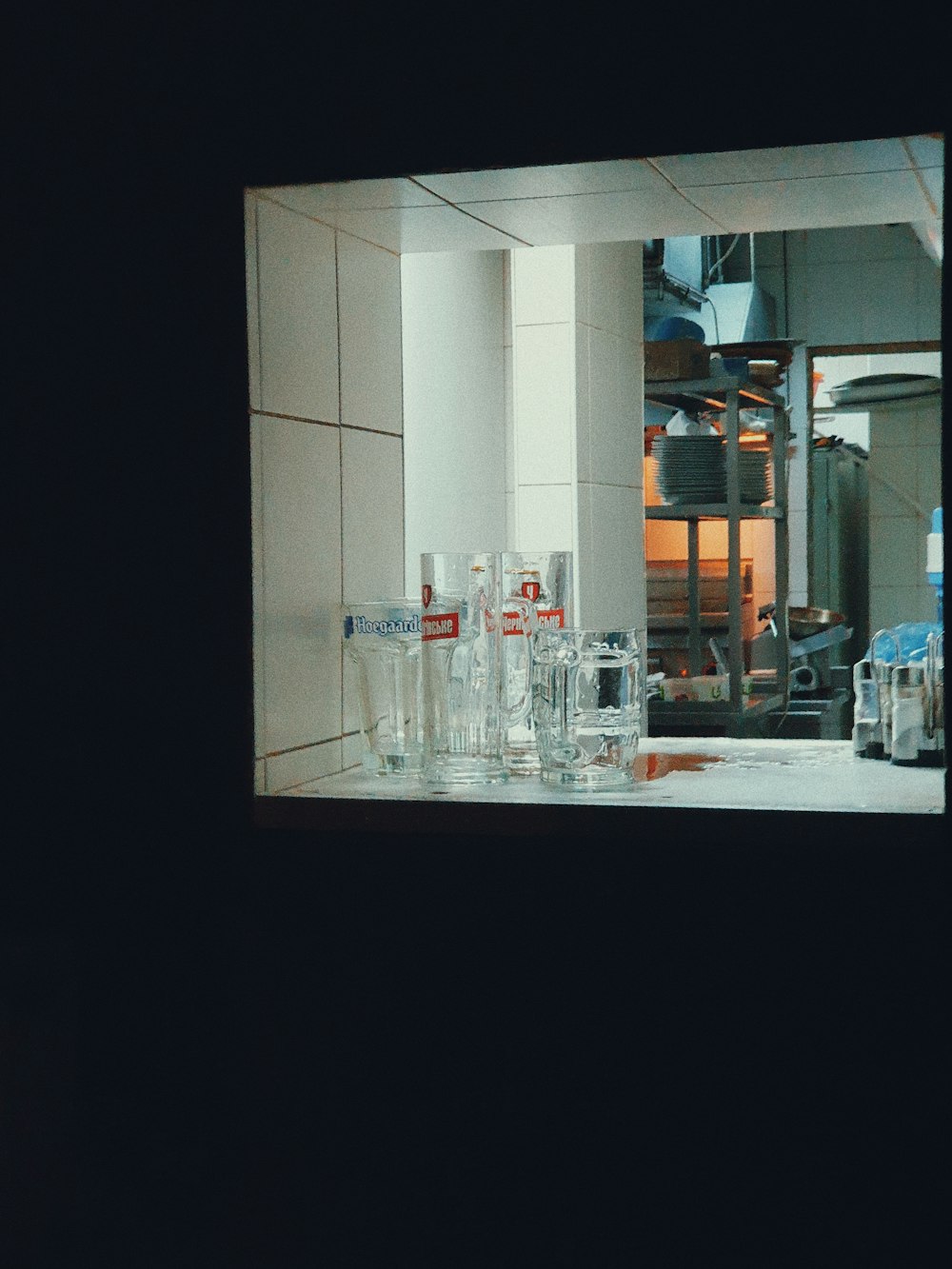 a kitchen counter with many glasses on it