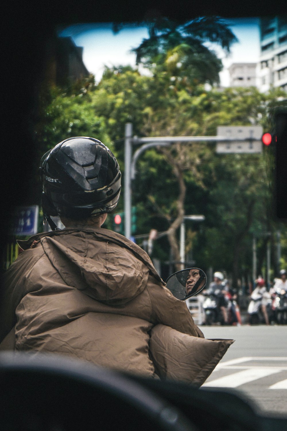 selective focus photography of person riding motorcycle near road during daytime