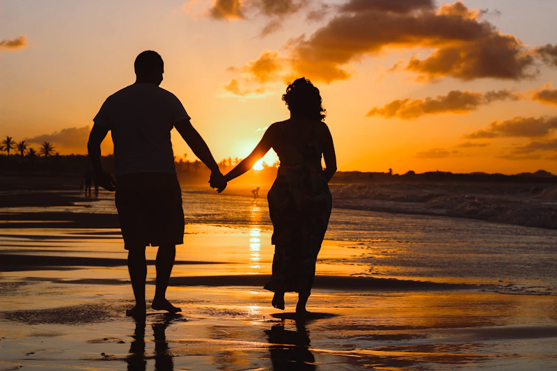 romantic couple standing by the water at golden hour