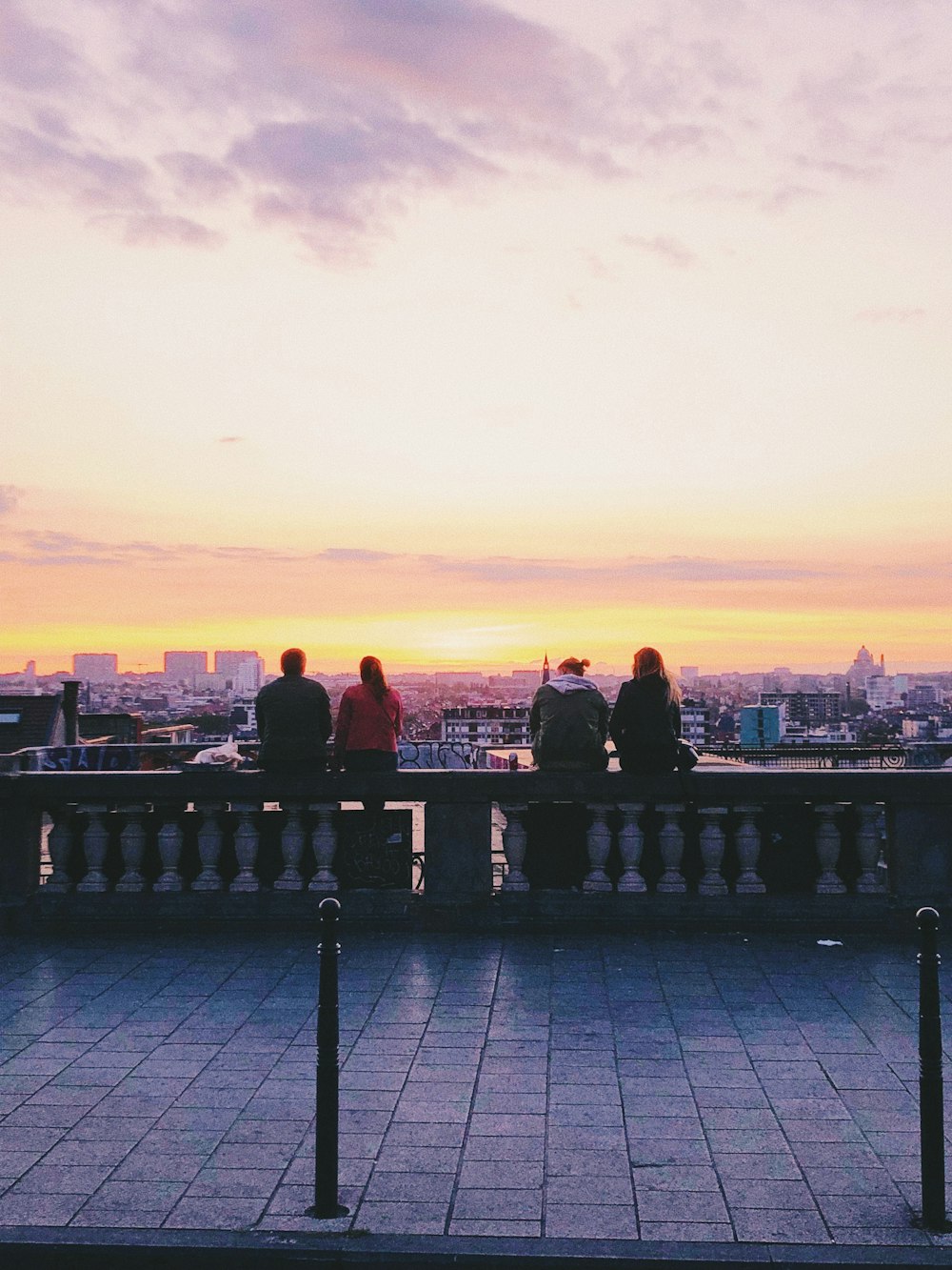 two pairs of couple sitting on concrete ground