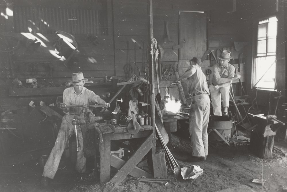 grayscale photography of men working inside building