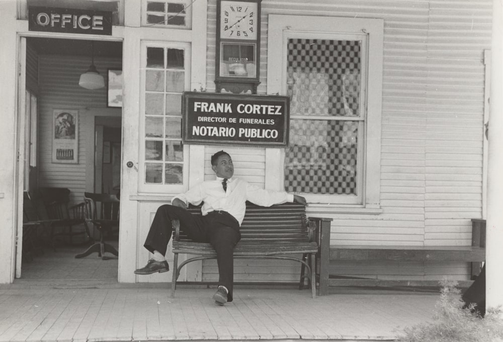 a man sitting on a bench in front of a store