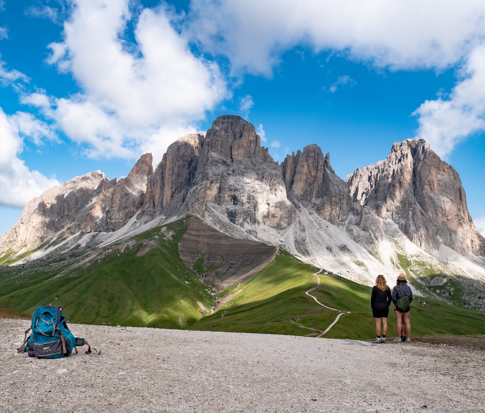 two person standing near gray mountain