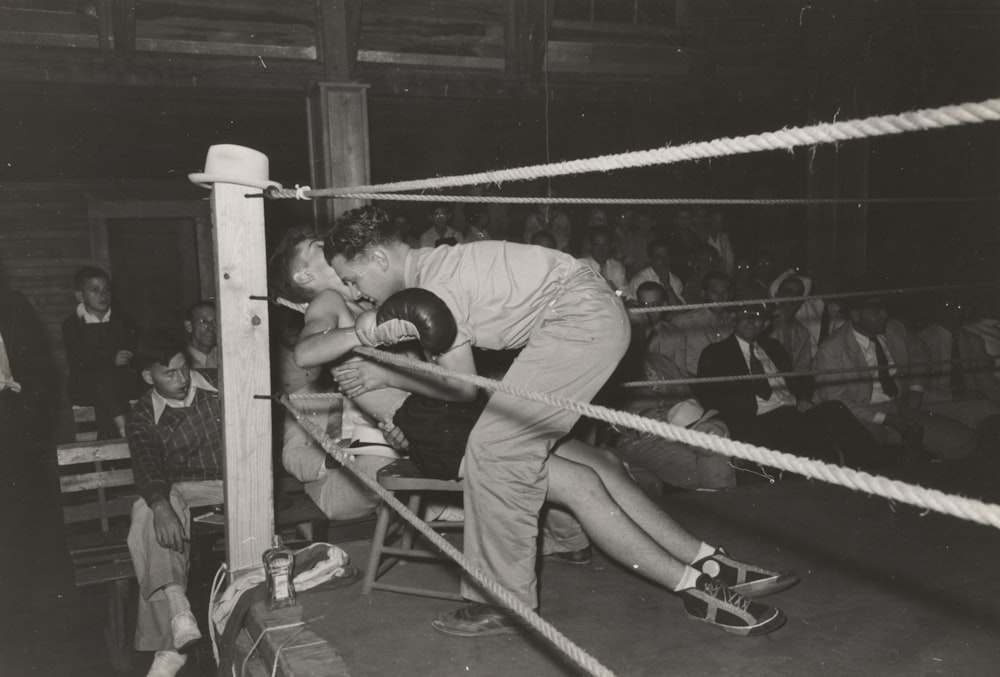 Foto en escala de grises de boxeador sentado y frente al hombre