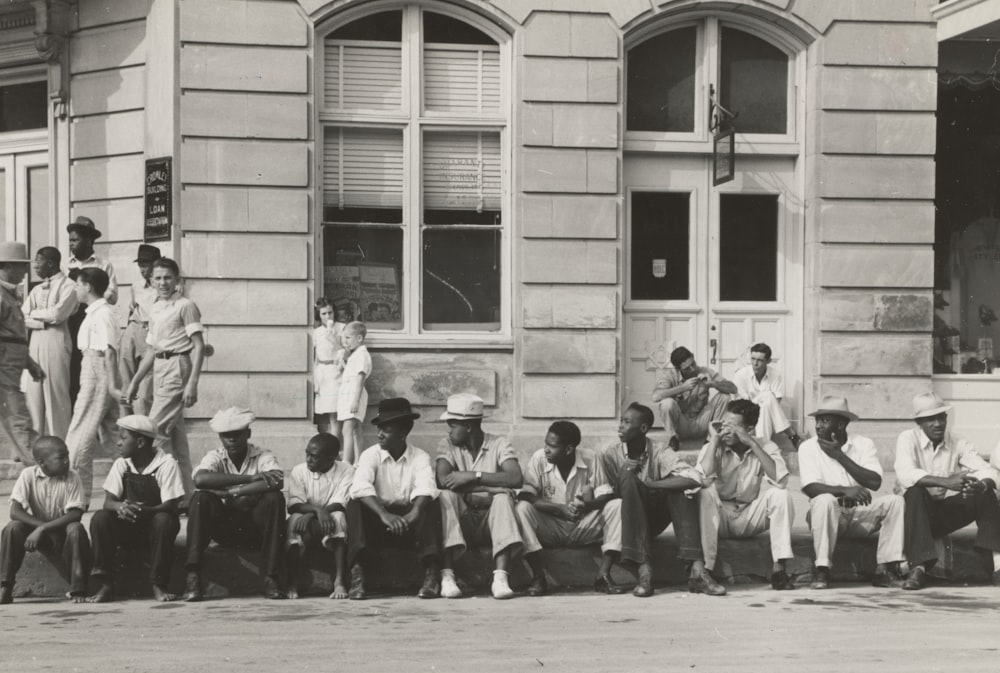 homens sentados em frente a edifícios